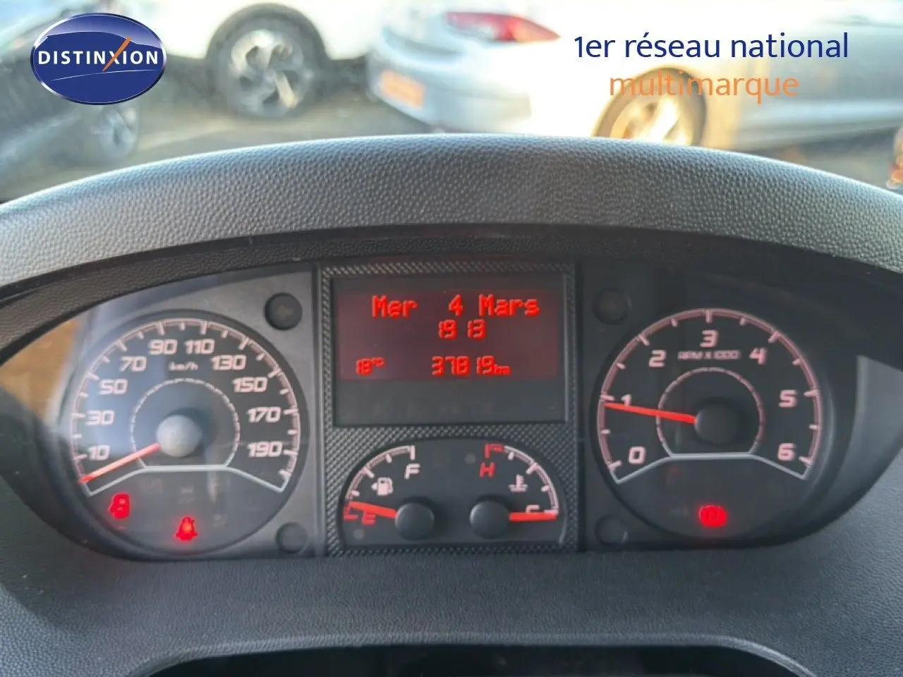 Vue rapprochée du tableau de bord du fourgon Opel Movano blanc, affichant le compteur et l'ordinateur de bord rouge.
