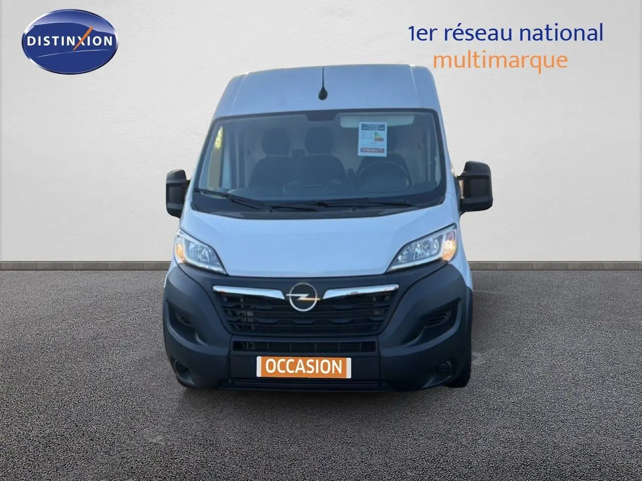 Vue avant d’un Opel Movano Fourgon blanc Icy 2023 avec calandre noire et plaque orange « Occasion » sur fond neutre.