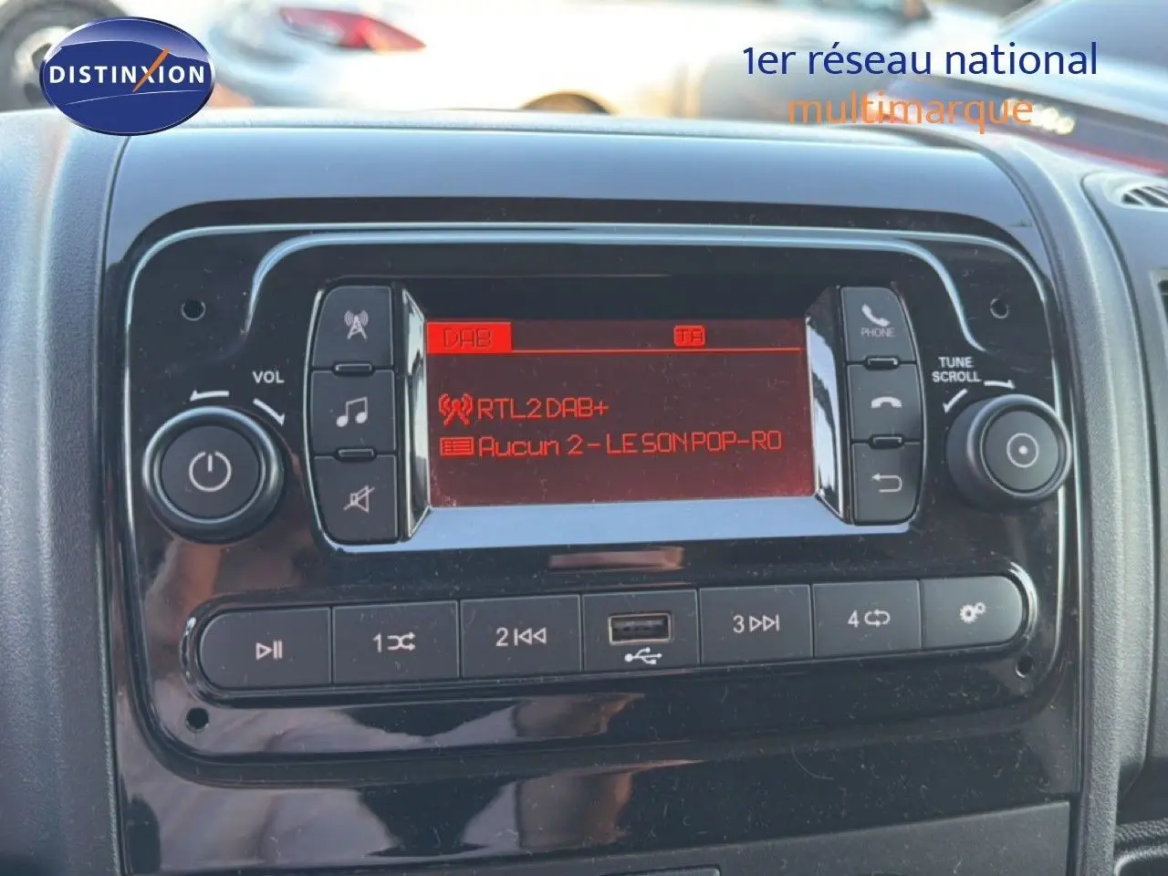 Détail du tableau de bord de l'Opel Movano Fourgon 2023 montrant l'autoradio avec écran rouge et commandes intégrées.