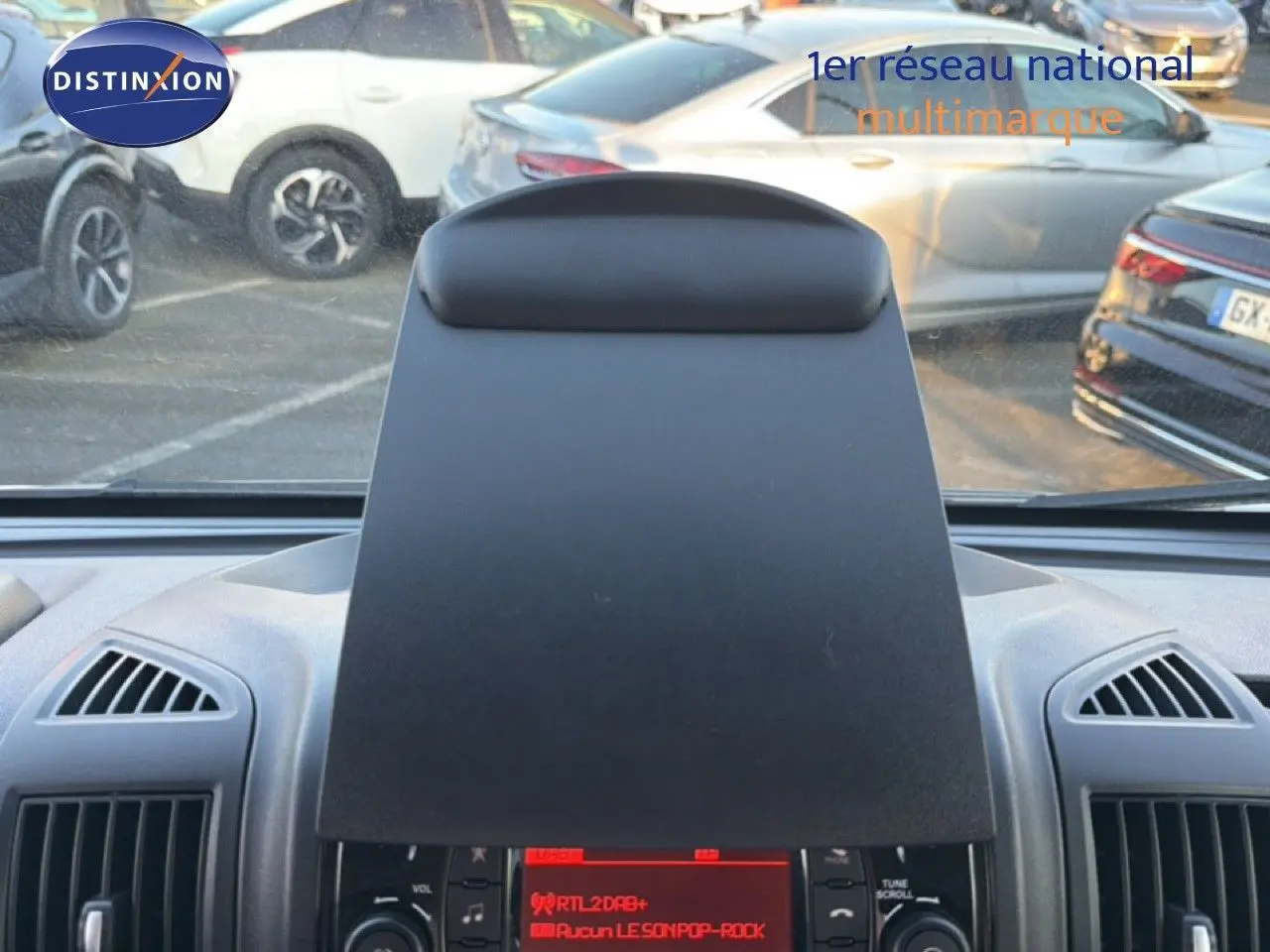 Vue intérieure centrée sur la console centrale noire du fourgon Opel Movano blanc, avec aérateurs visibles de chaque côté.