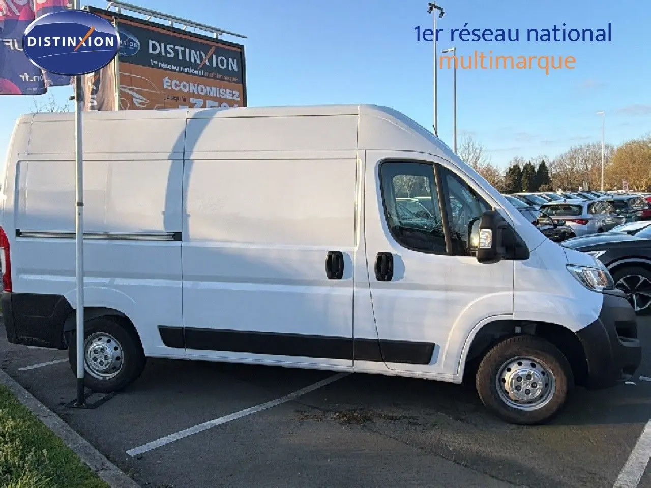 Opel Movano Fourgon blanc icy vu de profil côté droit, stationné sur un parking extérieur en journée.