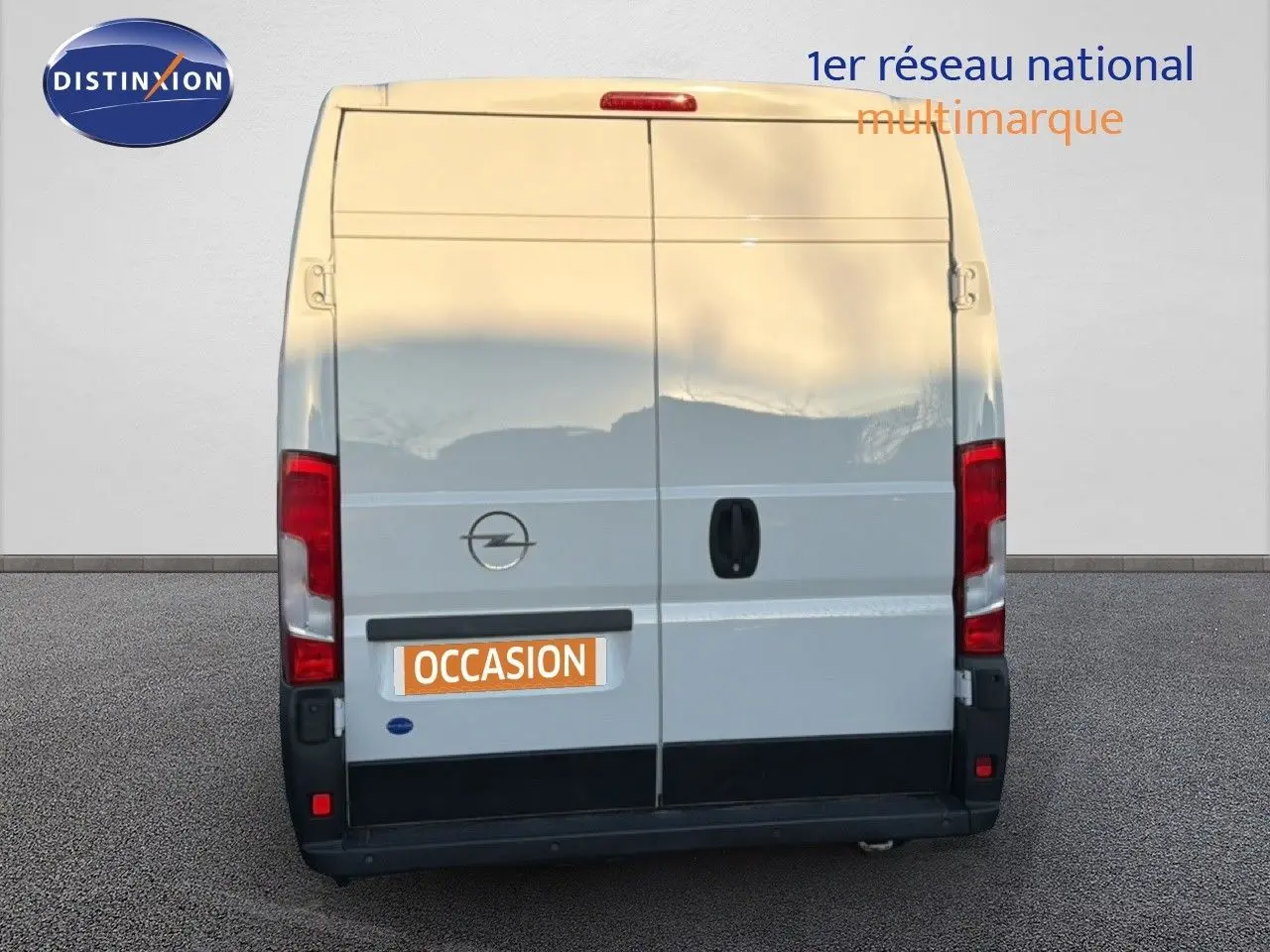 Vue arrière d’un fourgon Opel Movano blanc Icy, version L2H2, avec portes battantes fermées et logo Opel visible.