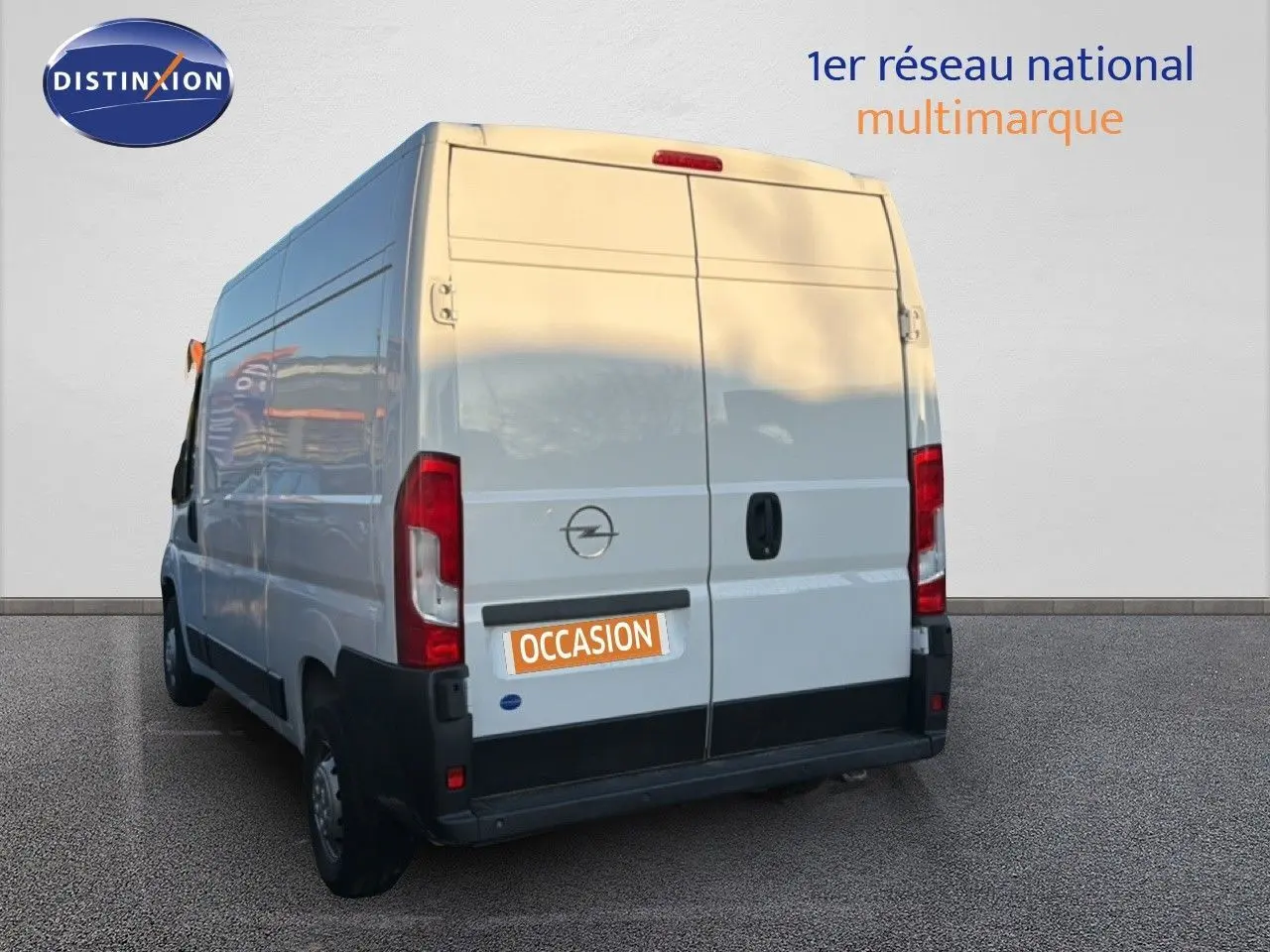 Vue 3/4 arrière gauche d’un Opel Movano Fourgon blanc icy, avec portes arrière fermées et logo Opel visible.