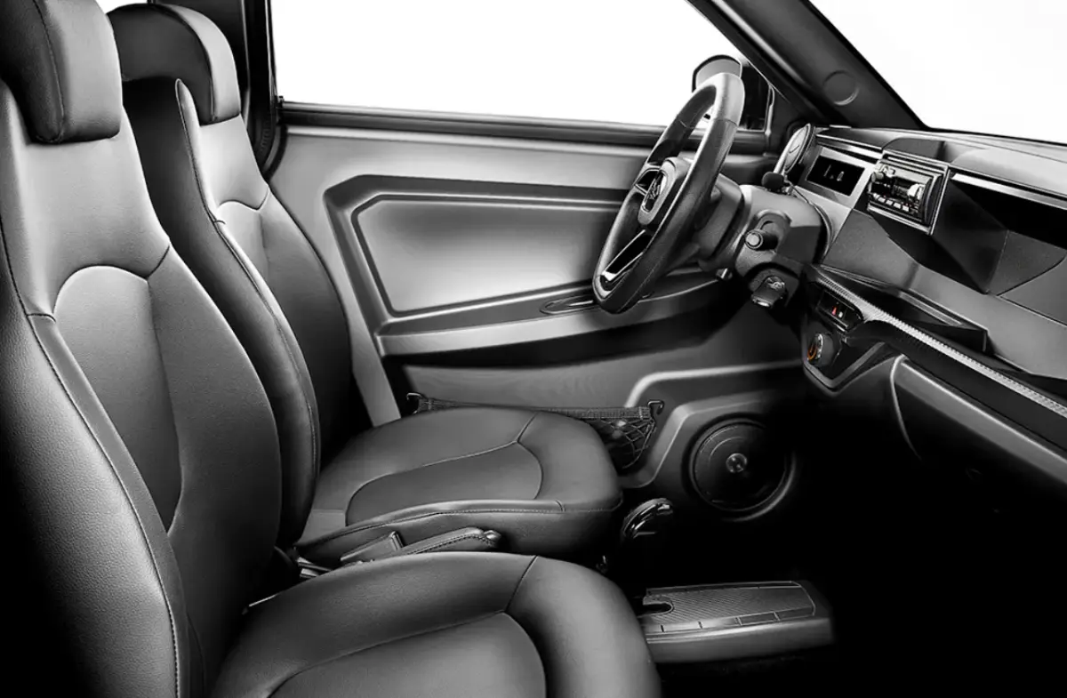 Vue intérieure côté conducteur de la LIGIER Myli 0.5 REVO D+ 2026, sièges simili-cuir noirs et tableau de bord moderne.