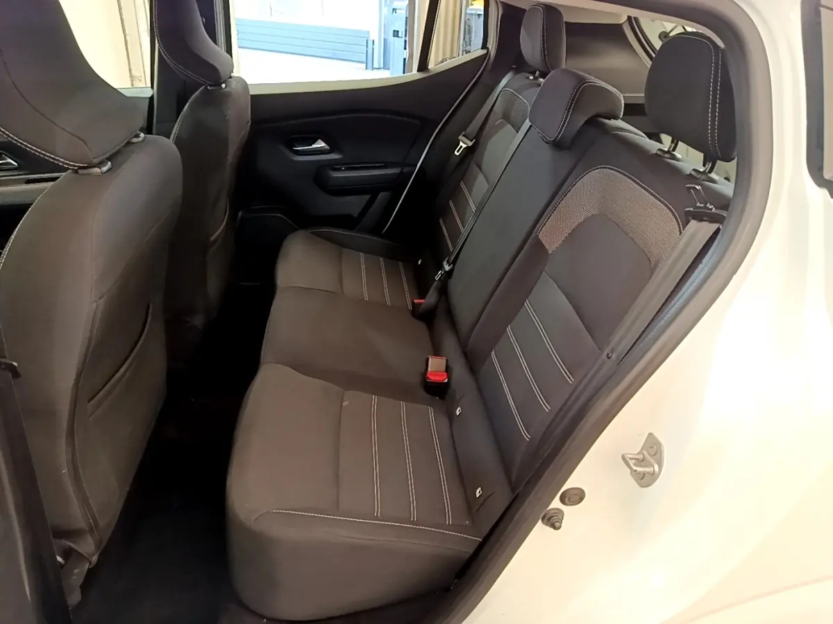 Vue intérieure côté droit sur la banquette arrière noire de la Dacia Sandero Confort TCe 90 blanche de 2022.