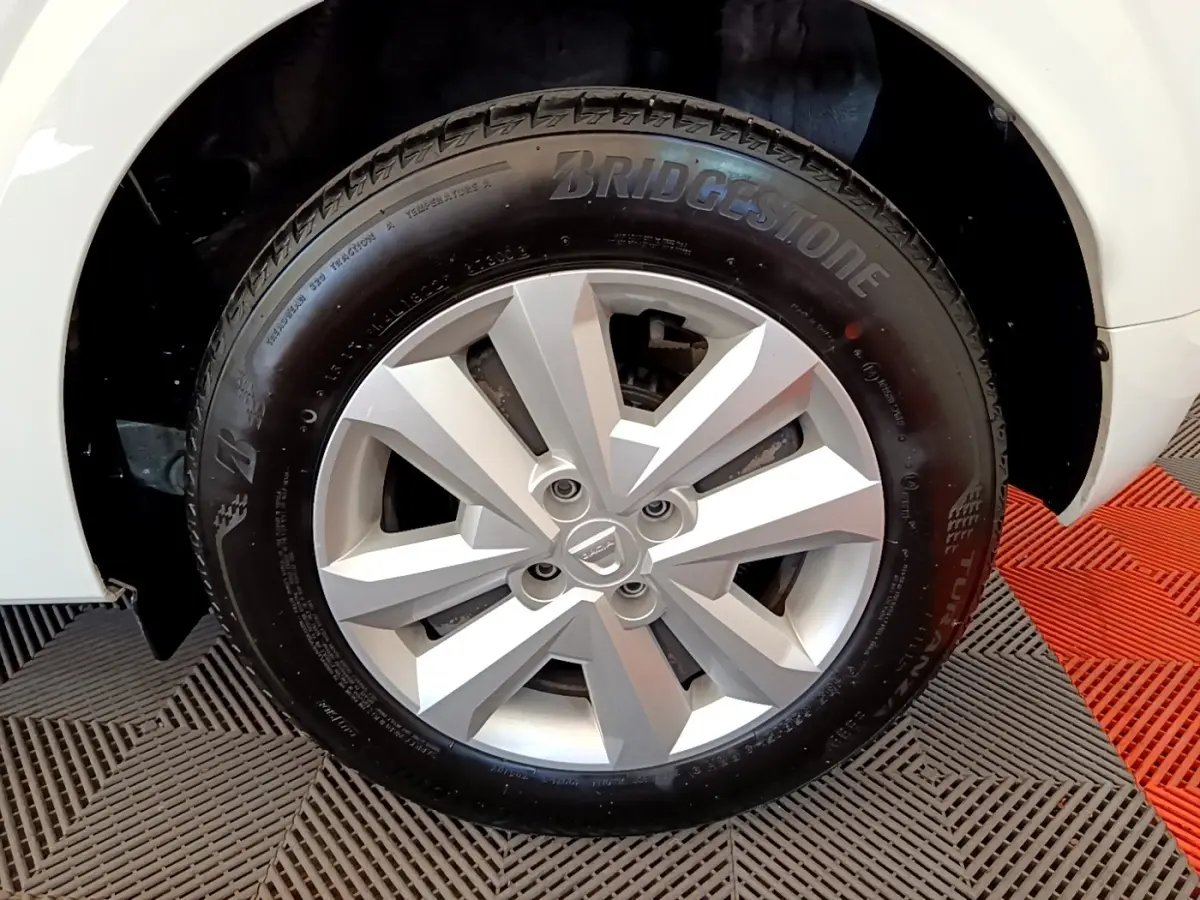 Gros plan sur la roue avant droite blanche d'une Dacia Sandero 2022 avec jante argentée et pneu Bridgestone.