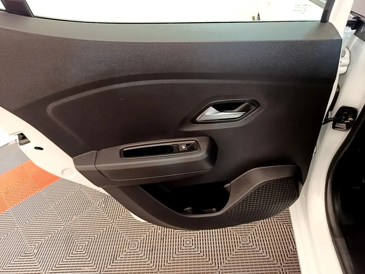 Vue rapprochée de la porte avant droite noire avec poignée argentée et bouton de verrouillage sur Dacia Sandero blanc 2022.