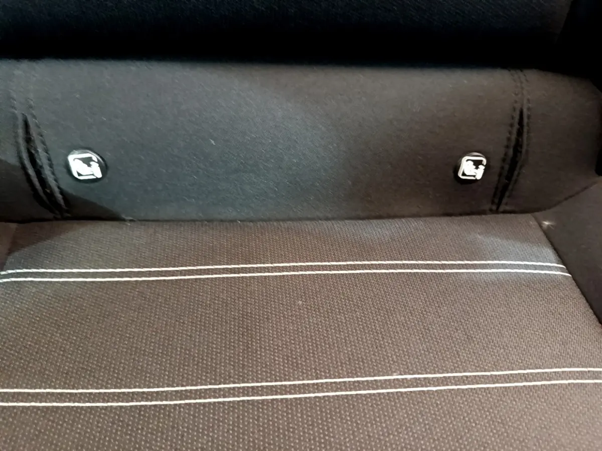 Gros plan sur la banquette arrière noire avec surpiqûres blanches et attaches Isofix de la Dacia Sandero Confort TCe 90.