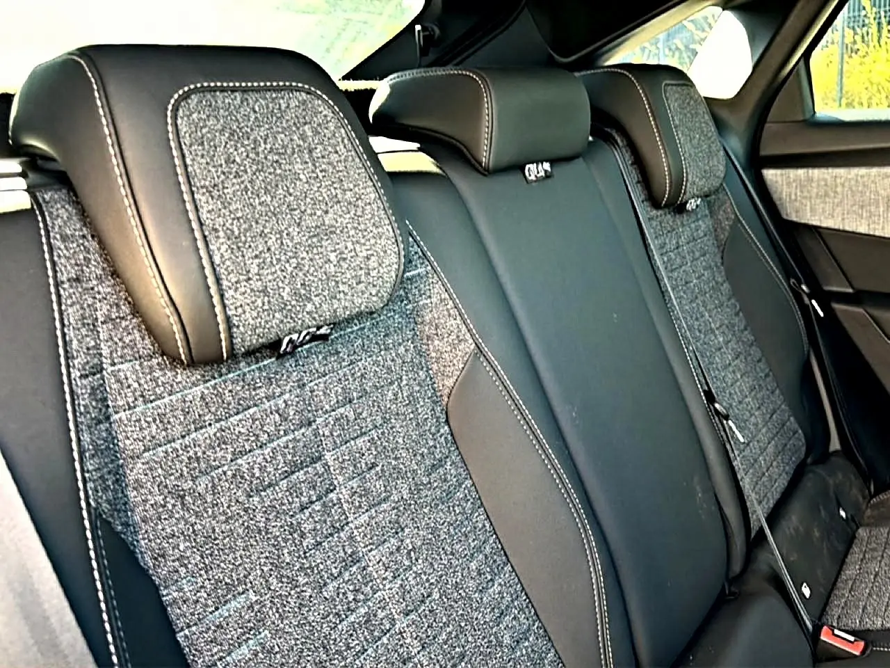 Vue rapprochée des sièges arrière en tissu gris et cuir noir du Peugeot 3008 1.2 hybrid 145 allure 2025.