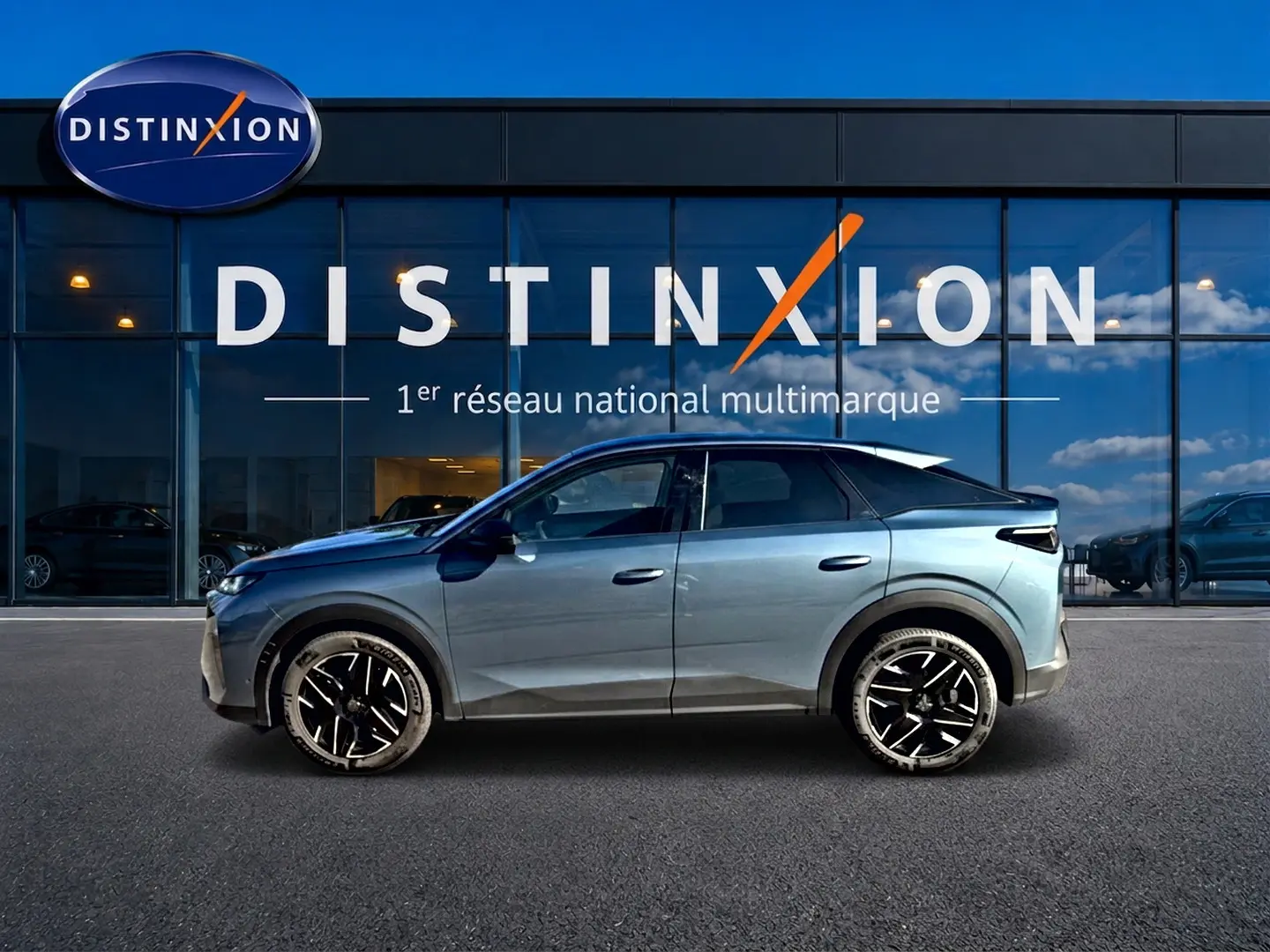 Vue de profil côté gauche d’un Peugeot 3008 bleu 2025 devant une vitrine avec logo Distinxion.