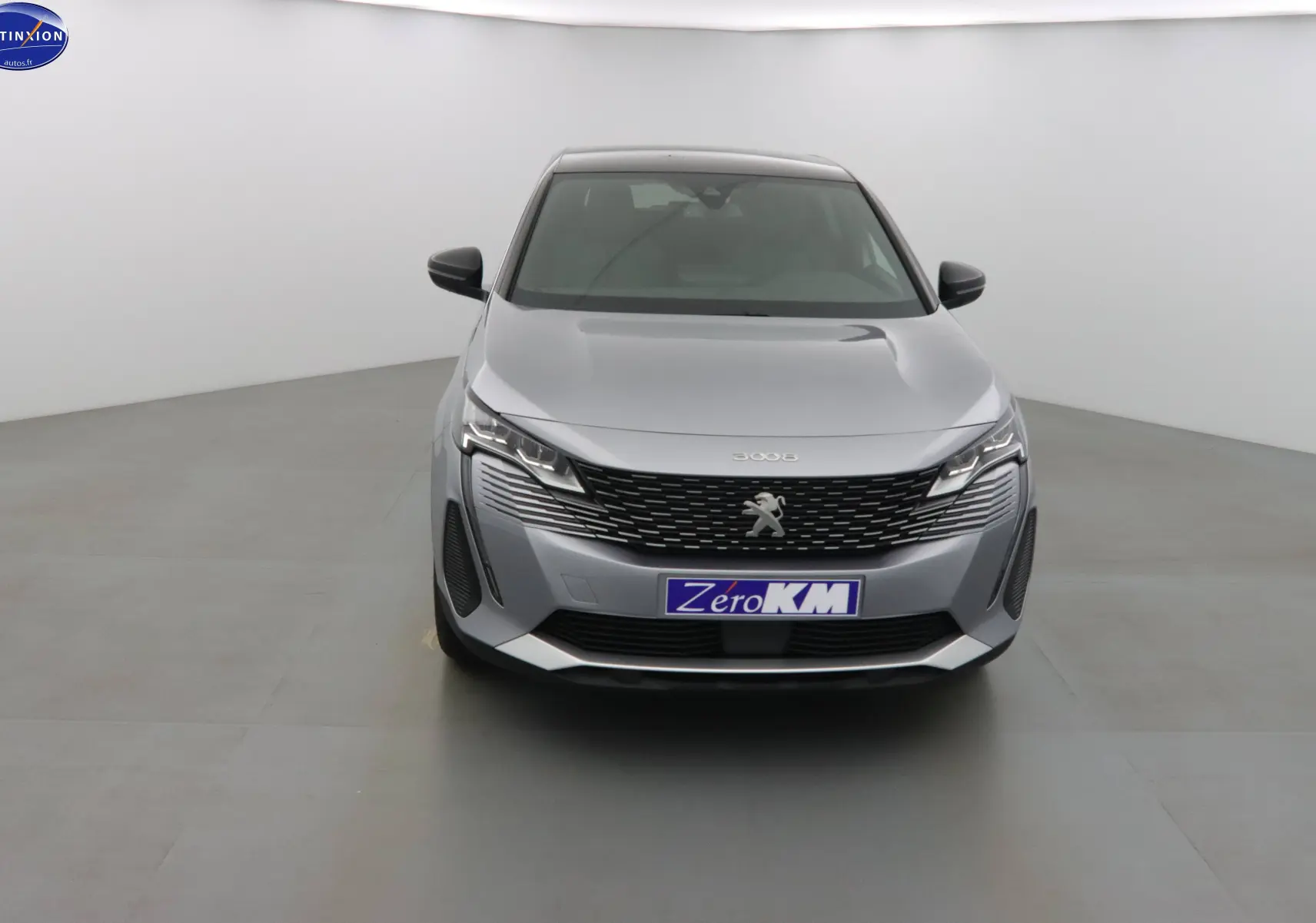 Peugeot 3008 gris Artense métal vue de face dans un studio, avec calandre noire et phares LED distinctifs.