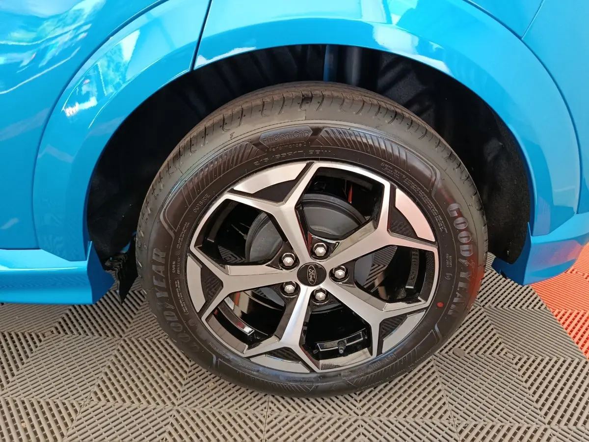 Gros plan sur la roue avant droite du Ford Puma bleu 2025 avec jante alliage noir et argentée design moderne.