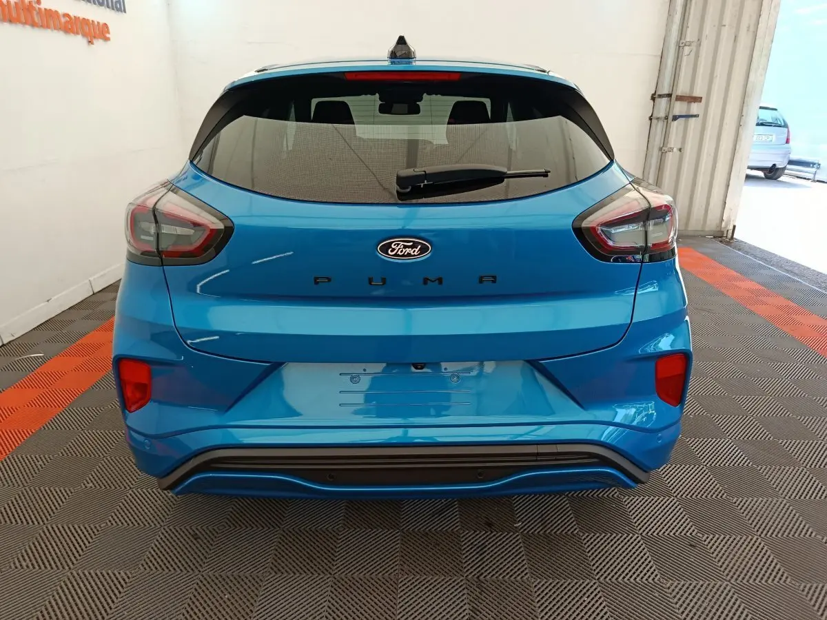 Vue arrière d'une Ford Puma bleu vif avec feux arrière LED et logo Ford centré sur le hayon.