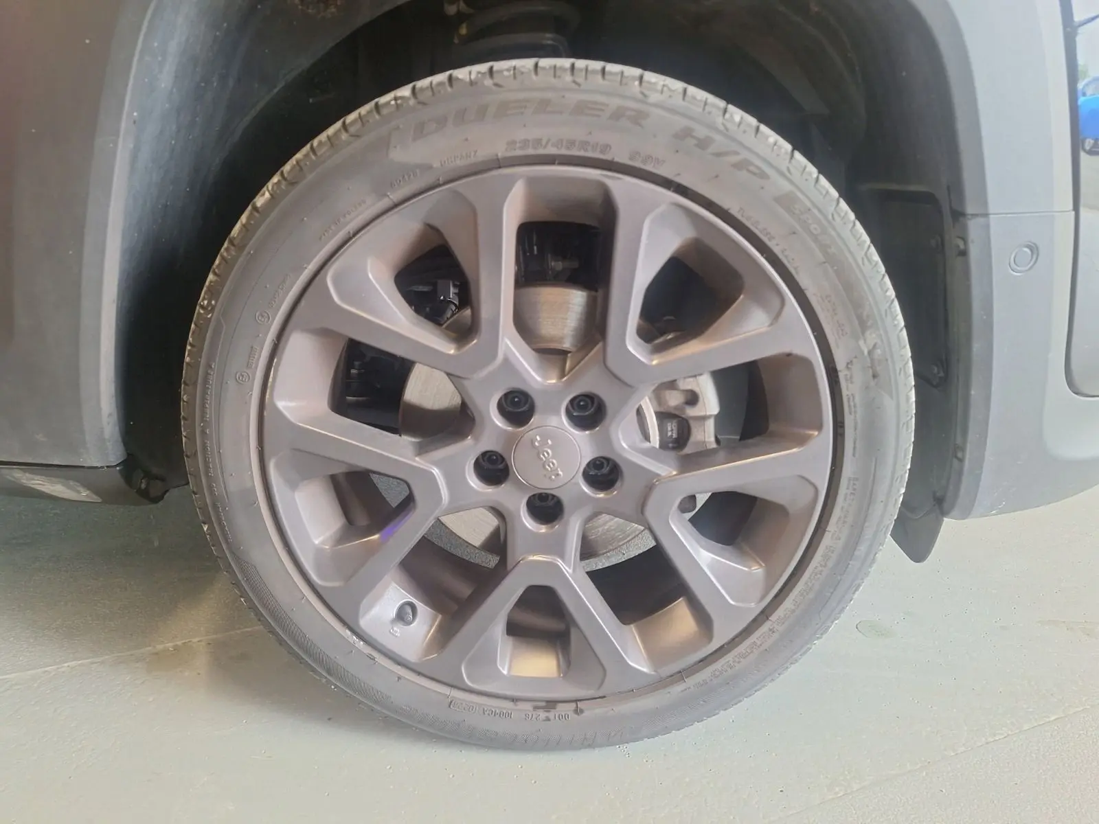 Gros plan sur la roue avant gauche noire d’un Jeep Renegade 2024 avec jante alliage 19 pouces et logo Jeep central.