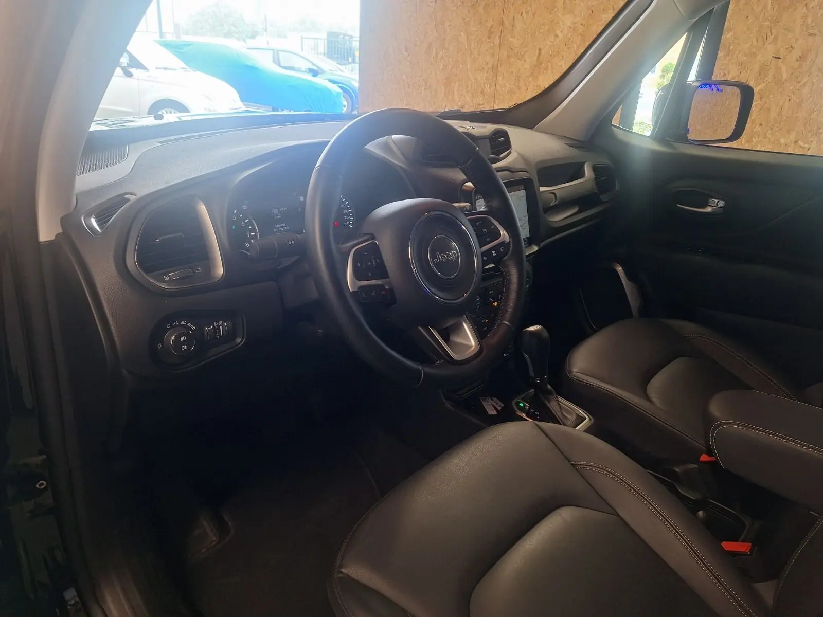 Intérieur noir du Jeep Renegade 2024 vu côté conducteur, avec volant cuir et tableau de bord moderne.