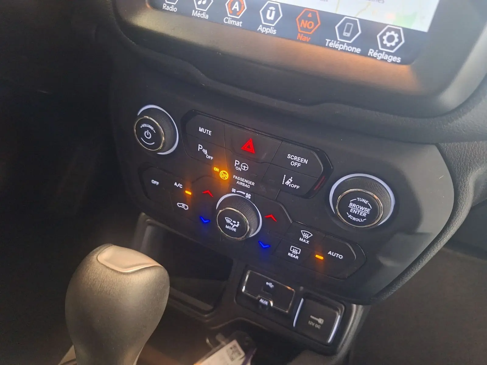 Vue rapprochée de la console centrale du Jeep Renegade noir 2024, montrant les commandes climatisation et le levier de vitesse automatique.