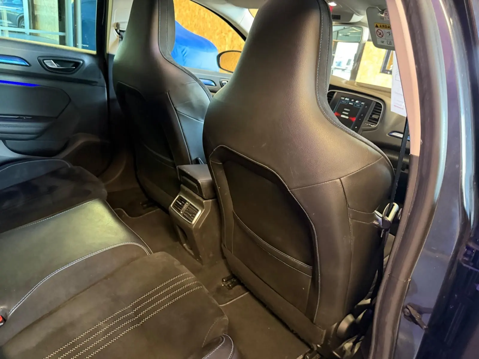 Vue intérieure arrière droite de la Renault Mégane Break GT 2017, sièges noirs en cuir et alcantara avec surpiqûres blanches.