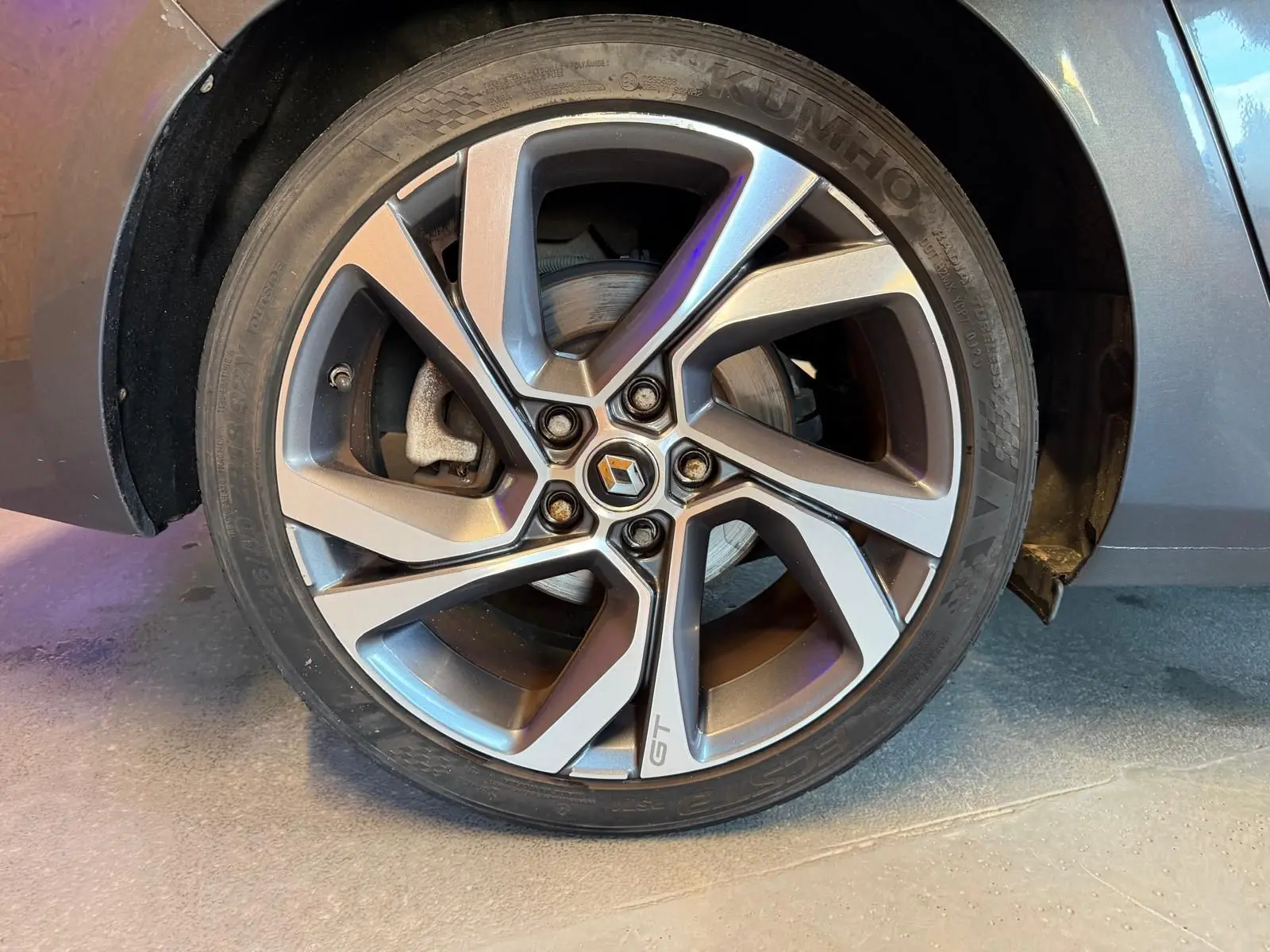 Gros plan sur la roue avant droite gris métallisé d'une Renault Mégane Break GT 2017 avec jante alliage marquée GT.