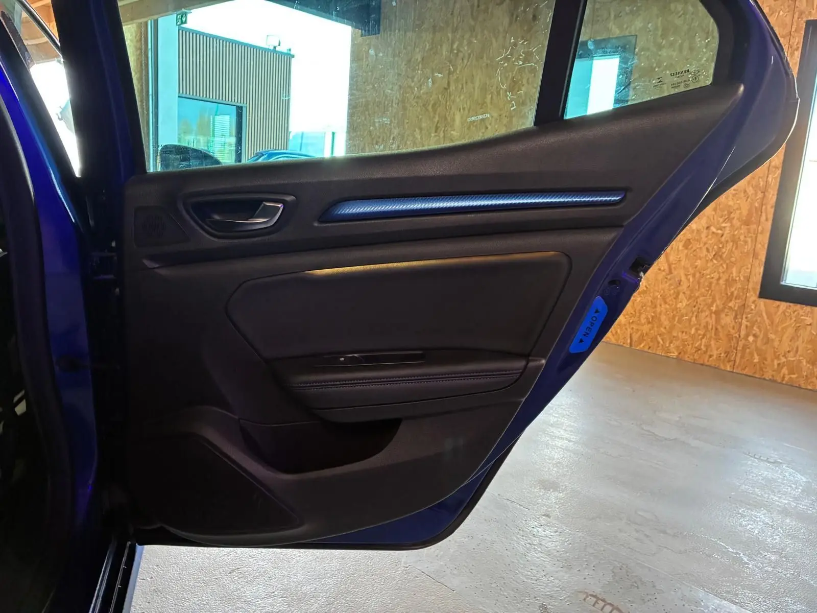 Vue intérieure de la porte arrière gauche bleu de la Renault Mégane 1.7 BlueDCI 150 GT Line avec garniture noire et insert décoratif.