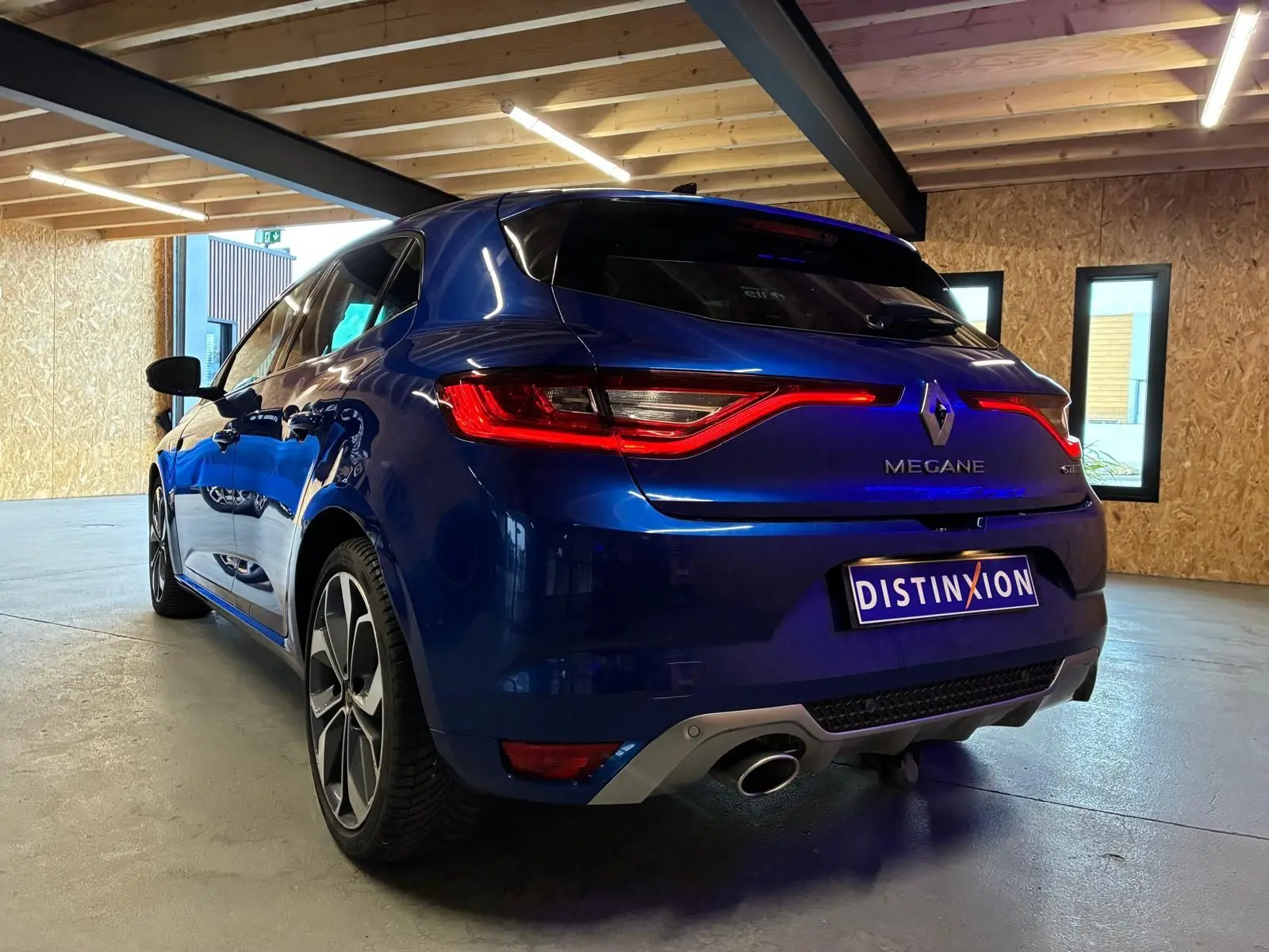 Vue 3/4 arrière droite d'une Renault Mégane 1.7 BlueDCI 150 GT Line bleu, avec feux LED et jantes alliage 18 pouces.