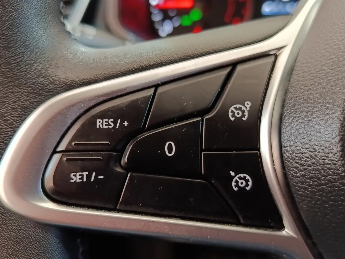 Gros plan sur les commandes du régulateur de vitesse au volant cuir synthétique de la Renault Clio Business Blue dCi 100.