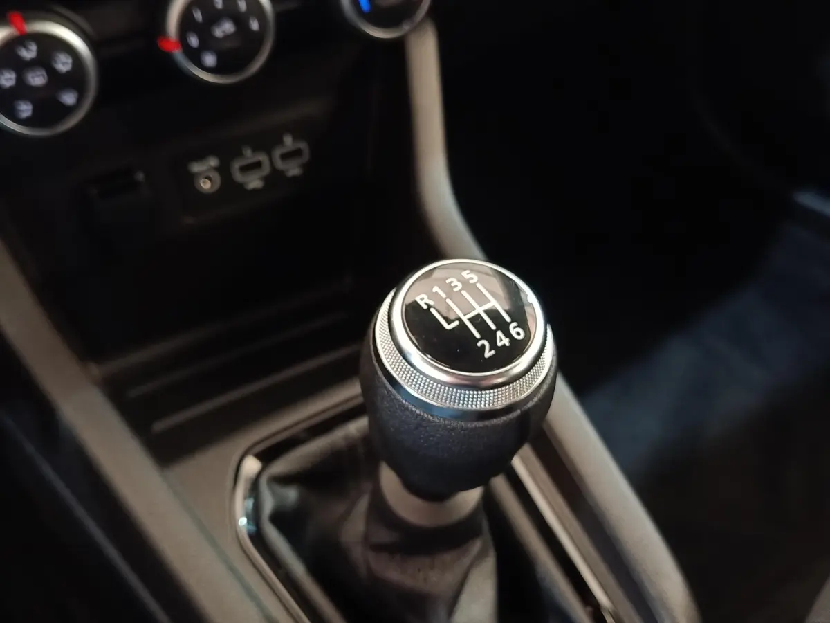Gros plan sur le levier de vitesse manuel de la Renault Clio Business Blue dCi 100, intérieur noir avec ports USB visibles.
