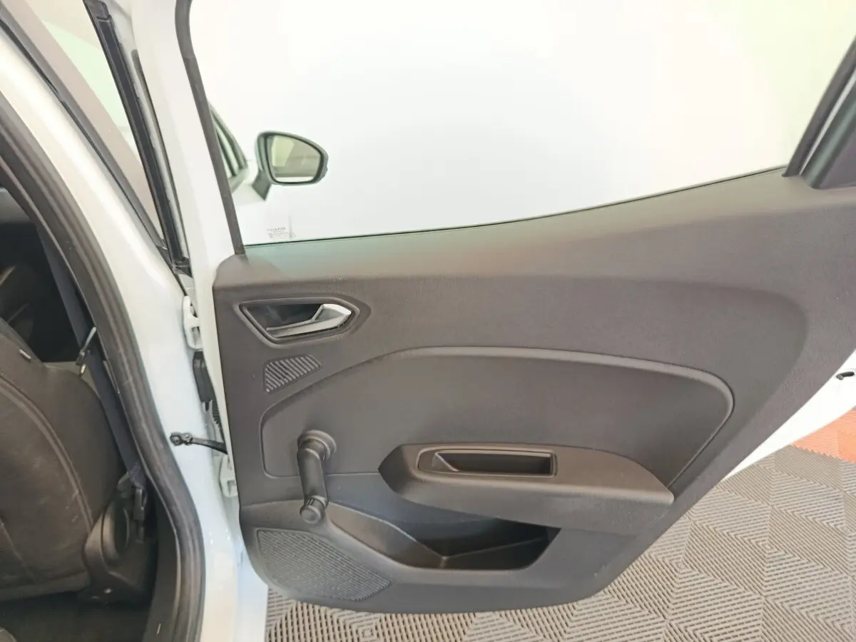 Vue intérieure sur la porte arrière gauche noire d'une Renault Clio Business Blue dCi 100 blanche, avec poignée manuelle.