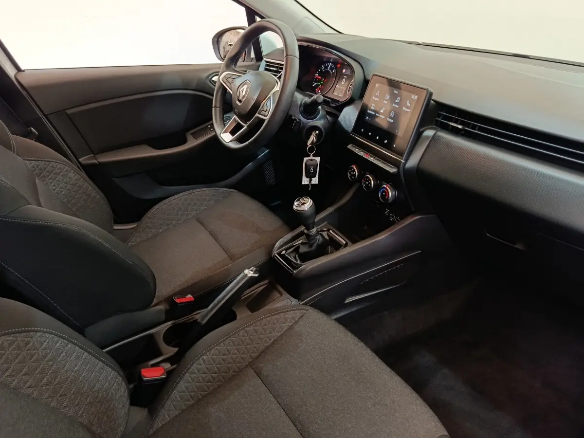 Vue intérieure côté conducteur de la Renault Clio Business 2022, volant cuir, tableau de bord avec écran tactile et boîte manuelle.