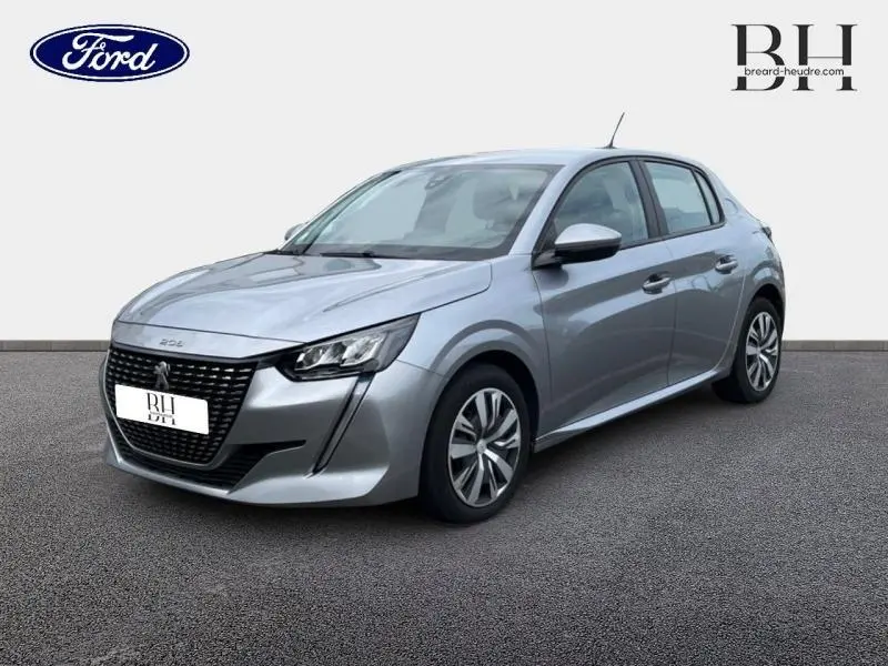Peugeot 208 gris Artense vue 3/4 avant droit, mettant en valeur sa calandre noire et ses phares LED distinctifs.