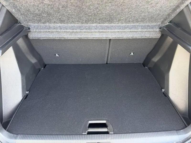 Coffre ouvert vu de face du Peugeot 2008 gris, montrant un espace de chargement propre et vide.