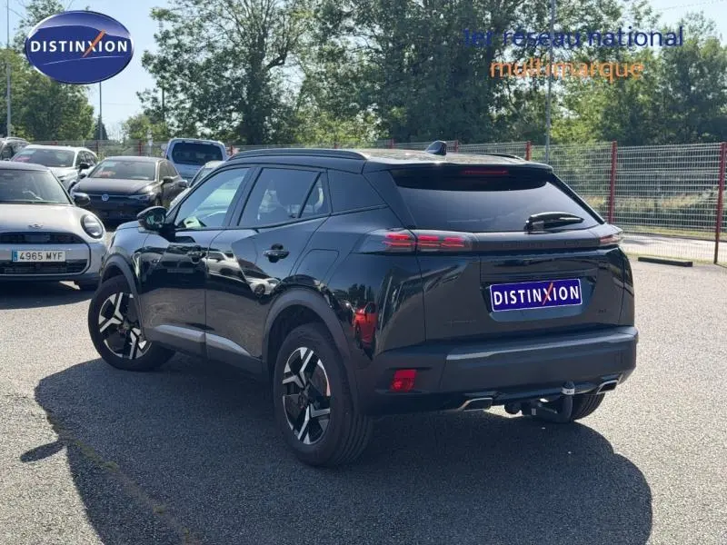 Vue 3/4 arrière droite d'un Peugeot 2008 gris avec jantes alu et feux arrière LED, stationné en extérieur.