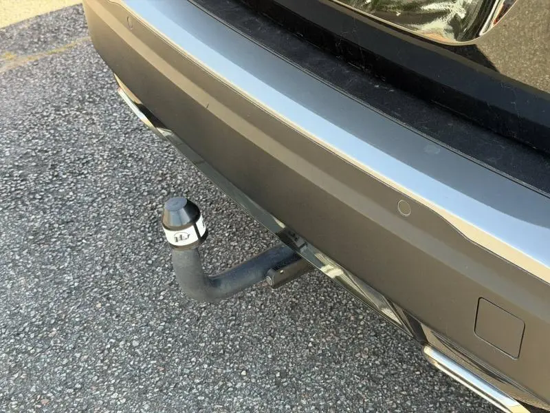 Gros plan sur l'attelage arrière gris d'une Peugeot 2008 2024, avec capteurs de stationnement intégrés.