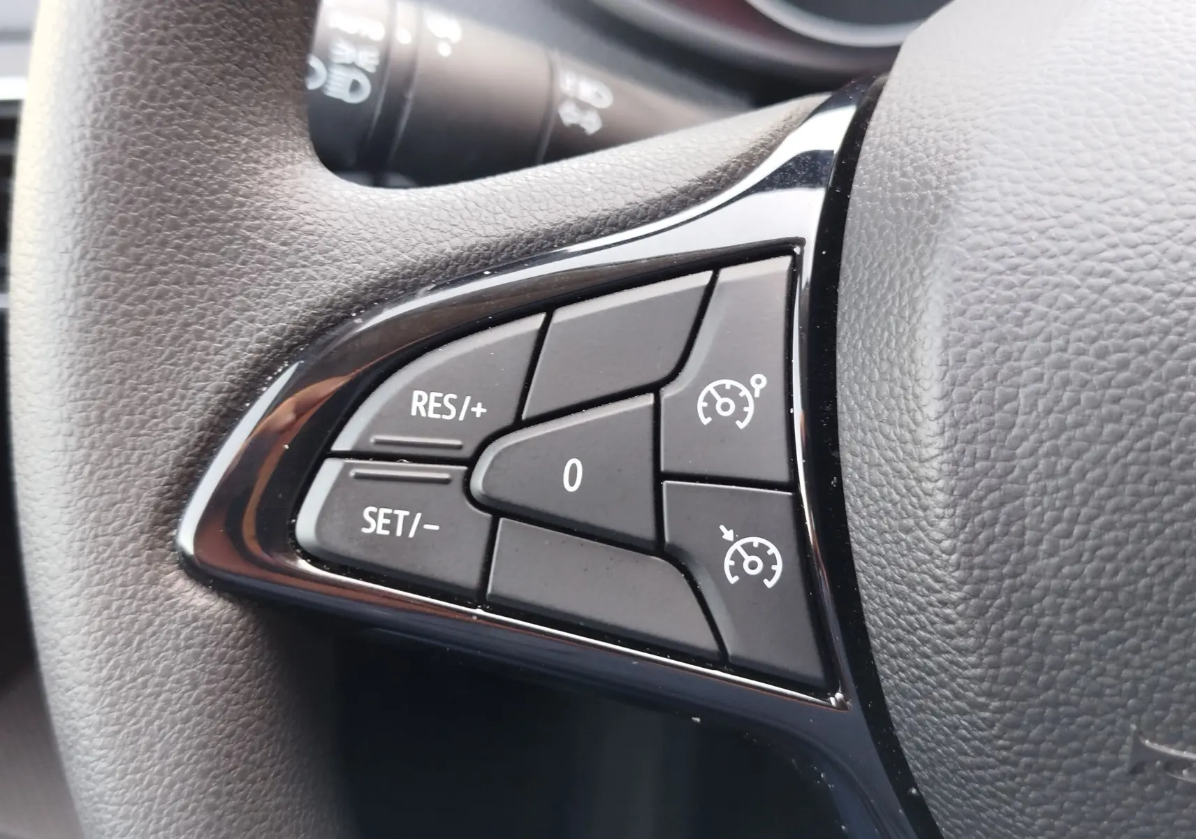 Gros plan sur les commandes de régulateur de vitesse au volant du Dacia Sandero 2025, finition Essentiel.