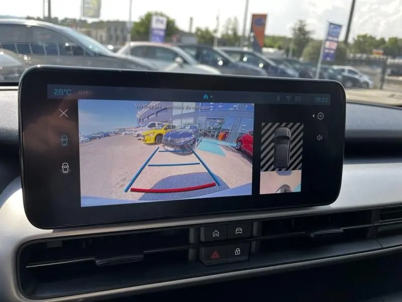 Vue arrière via caméra de recul du Jeep Avenger blanc 2025, avec lignes de guidage et environnement de parking visible.