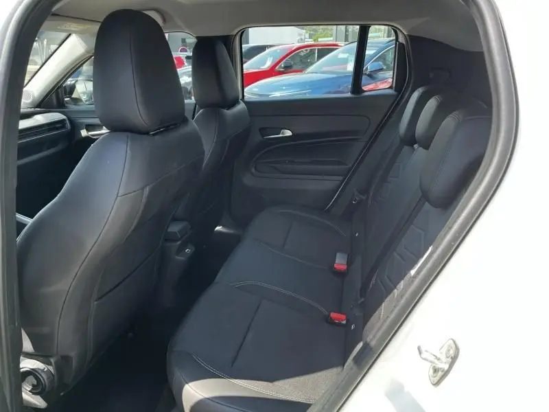 Vue intérieure arrière côté droit du Jeep Avenger blanc 2025, sièges noirs et garnitures sobres visibles.