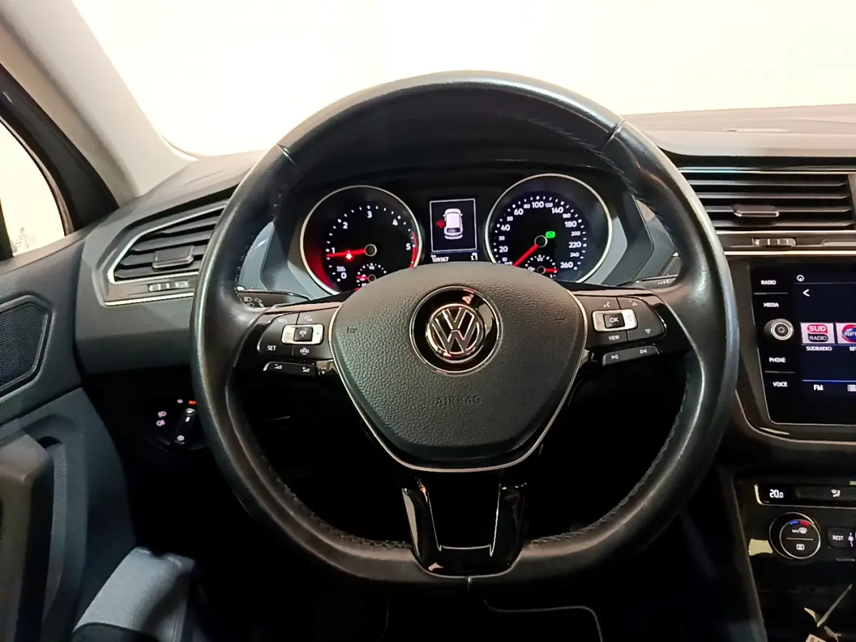 Vue rapprochée du volant cuir multifonctions et du tableau de bord numérique du Volkswagen Tiguan gris clair 2020.