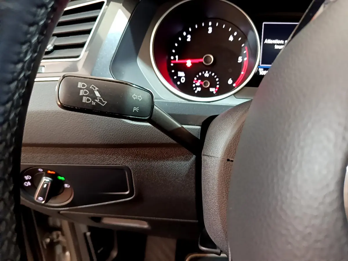 Gros plan sur la manette de clignotants et le tableau de bord noir du Volkswagen Tiguan 2.0 TDI 2020, côté gauche du volant.