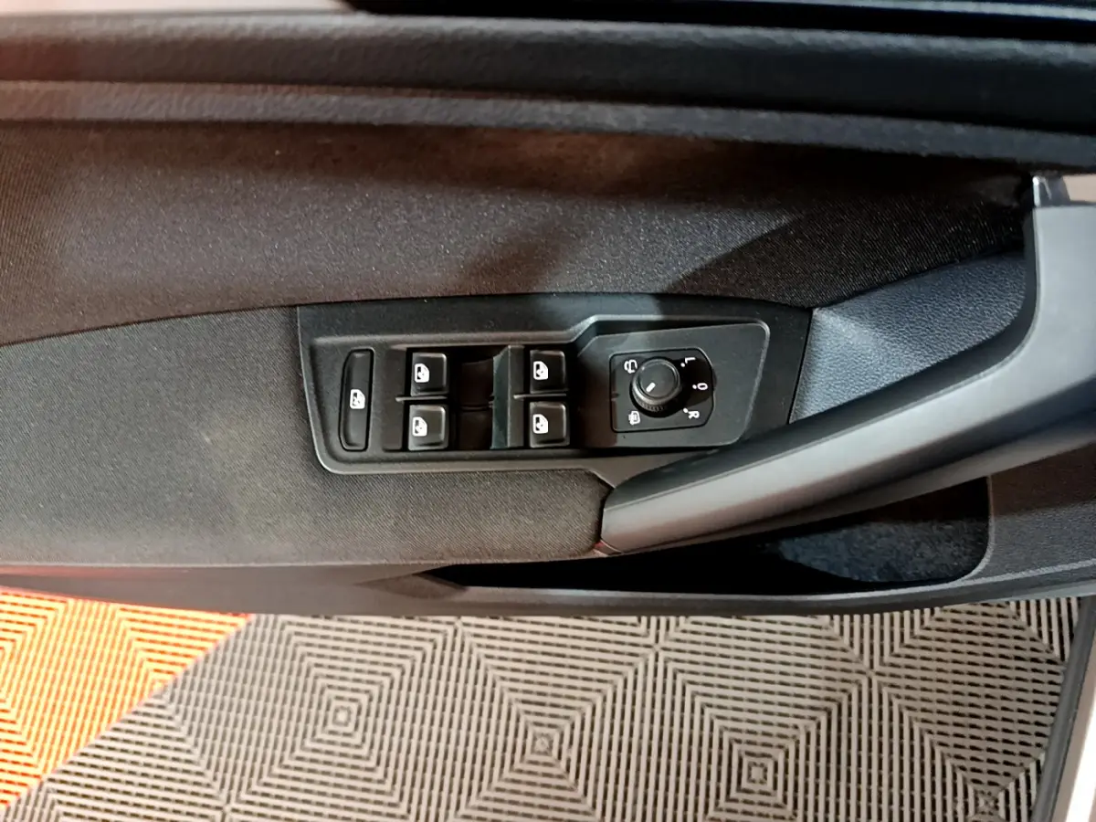 Panneau de commandes des vitres et rétroviseurs sur la porte côté gauche d'un Volkswagen Tiguan gris clair 2020.