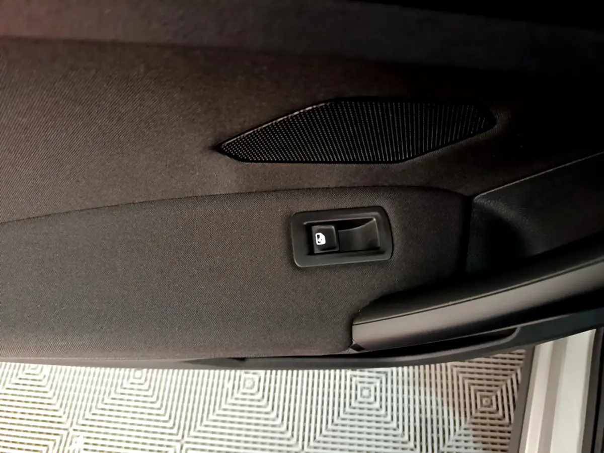 Détail de la poignée intérieure de porte arrière droite noire du Volkswagen Tiguan 2020 gris clair.