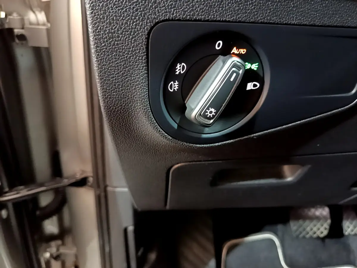 Gros plan sur le bouton de commande des phares à gauche du volant dans un Volkswagen Tiguan gris clair 2020