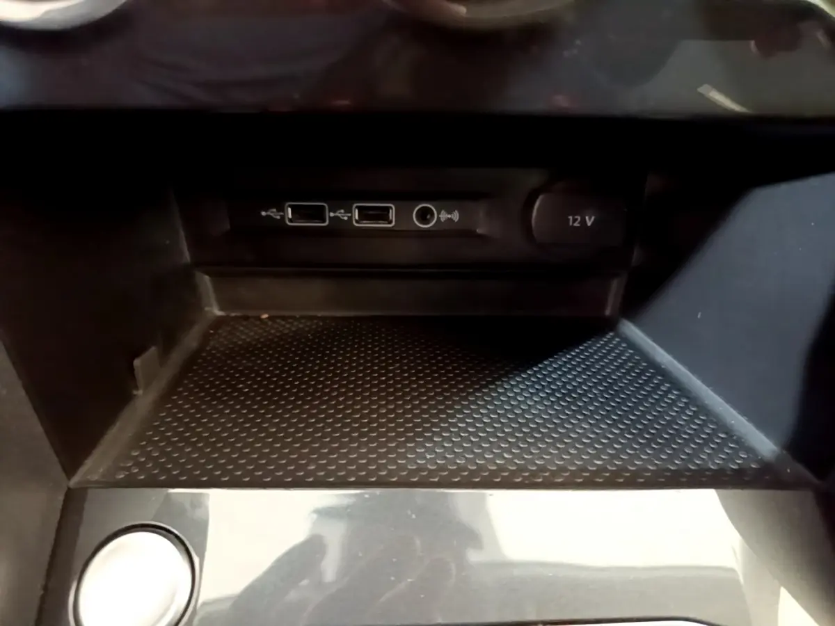 Gros plan sur la console centrale noire du Volkswagen Tiguan 2.0 TDI avec ports USB et prise 12V visibles