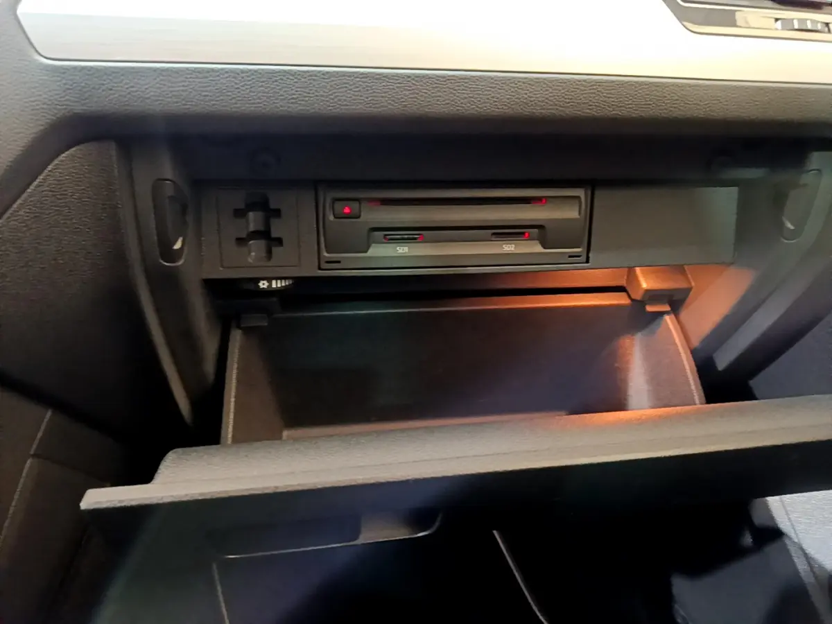 Gros plan sur la boîte à gants ouverte du Volkswagen Tiguan 2020 avec lecteur SD intégré et éclairage intérieur.