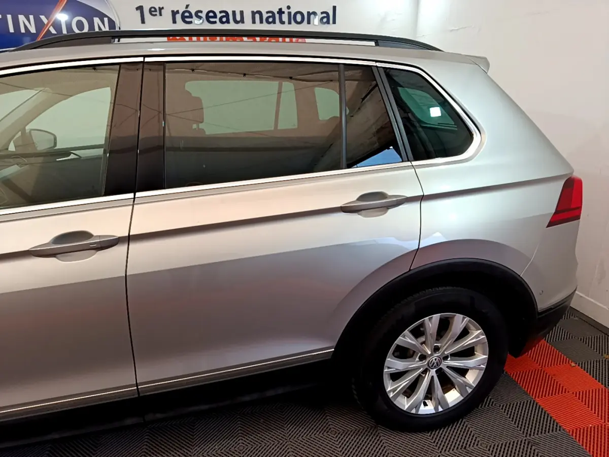 Vue latérale côté droit du Volkswagen Tiguan gris clair 2020 avec jante alliage et vitres teintées.