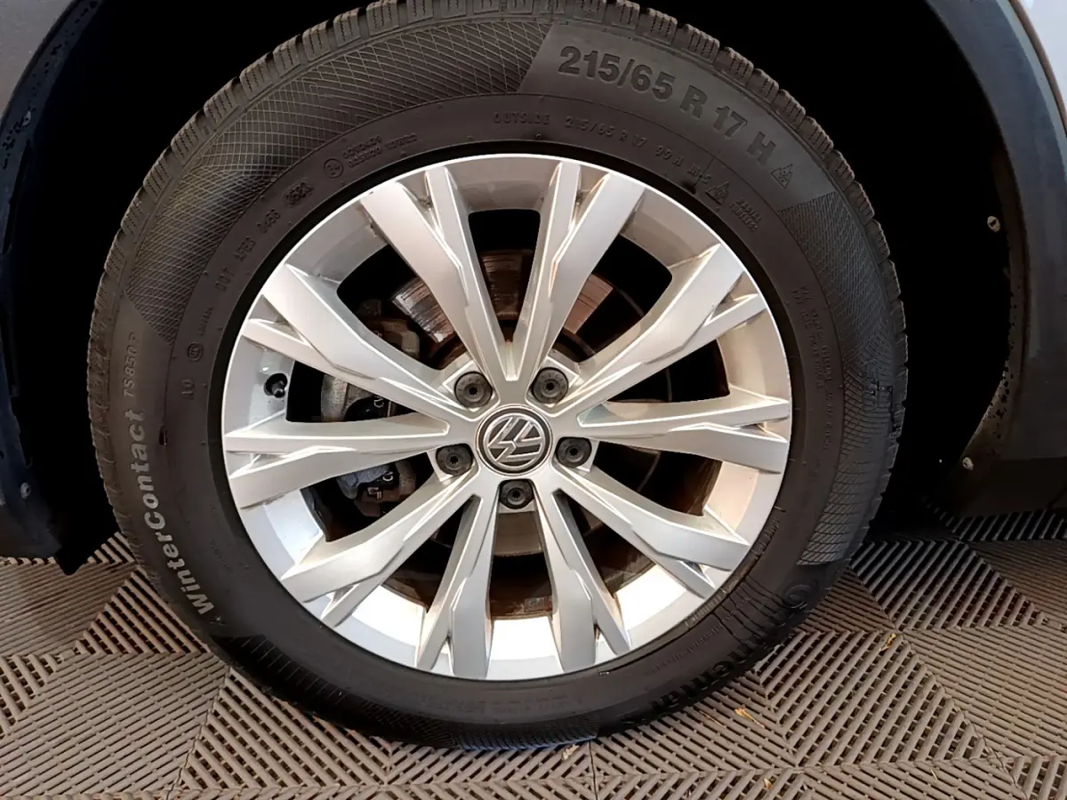 Gros plan sur la jante alliage argentée avec logo Volkswagen du Volkswagen Tiguan gris clair 2020.