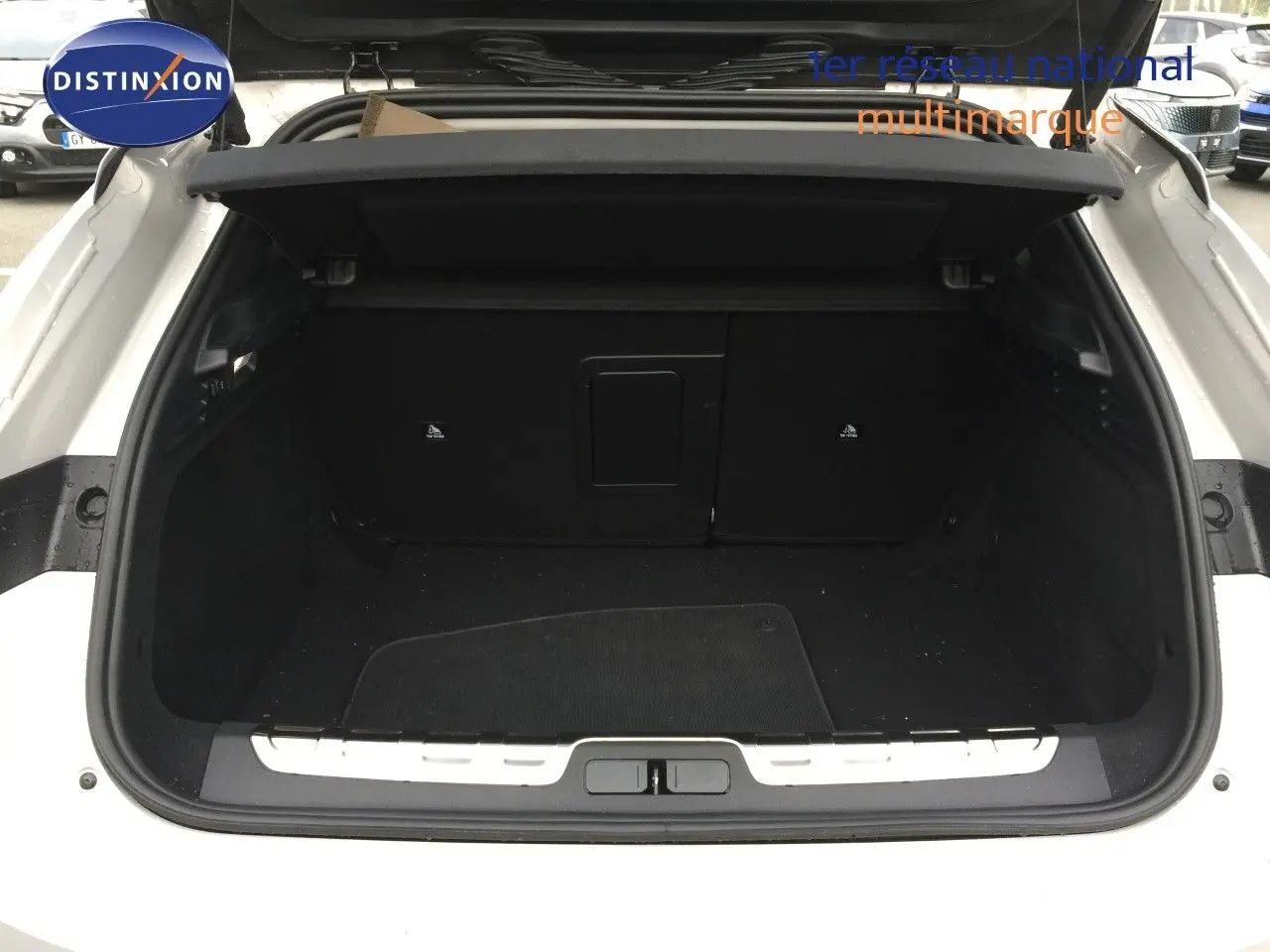 Coffre ouvert vu de l'arrière d'une DS4 2024 Eph chrystal, montrant l'espace de chargement noir et la plage arrière.