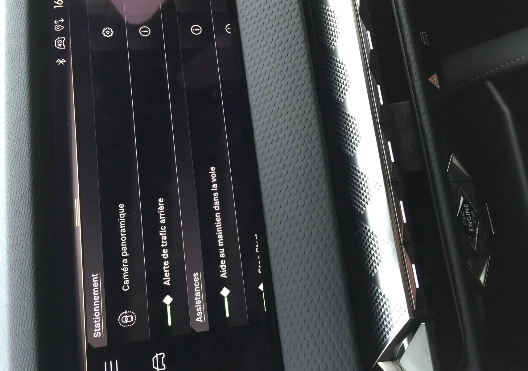 Détail de l'écran tactile central du DS4 2024 montrant les options d'assistance à la conduite, avec tableau de bord noir texturé.
