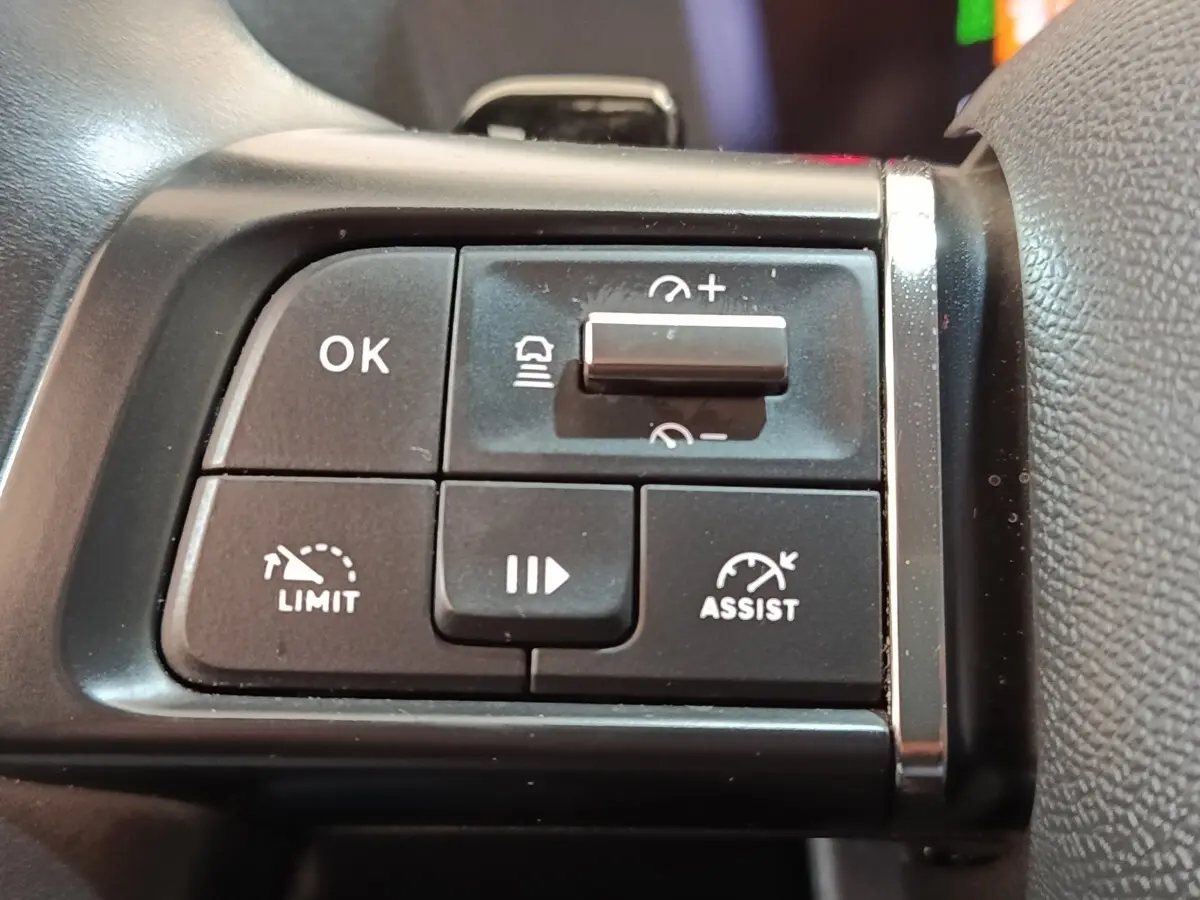 Gros plan sur les commandes noires du volant côté gauche de la Citroën C4 2022, avec boutons de régulateur et limiteur de vitesse.