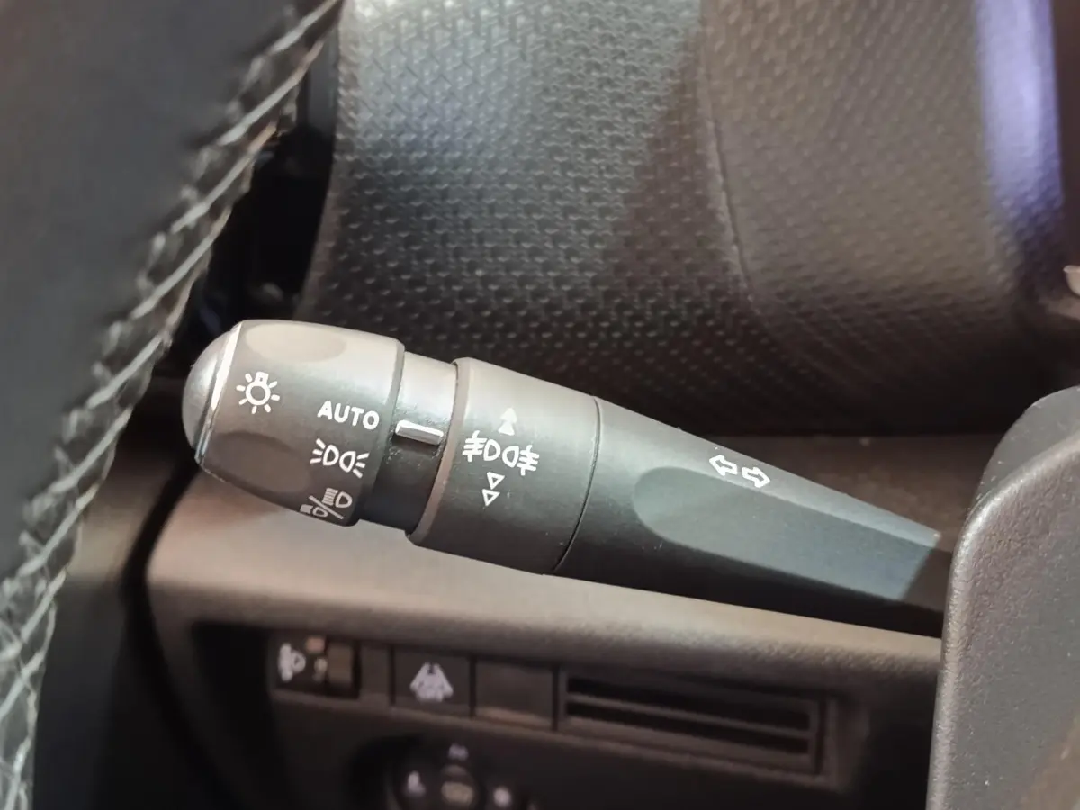 Gros plan sur la commande des feux et clignotants dans l’habitacle d’une Citroën C4 gris foncé, version 2022.