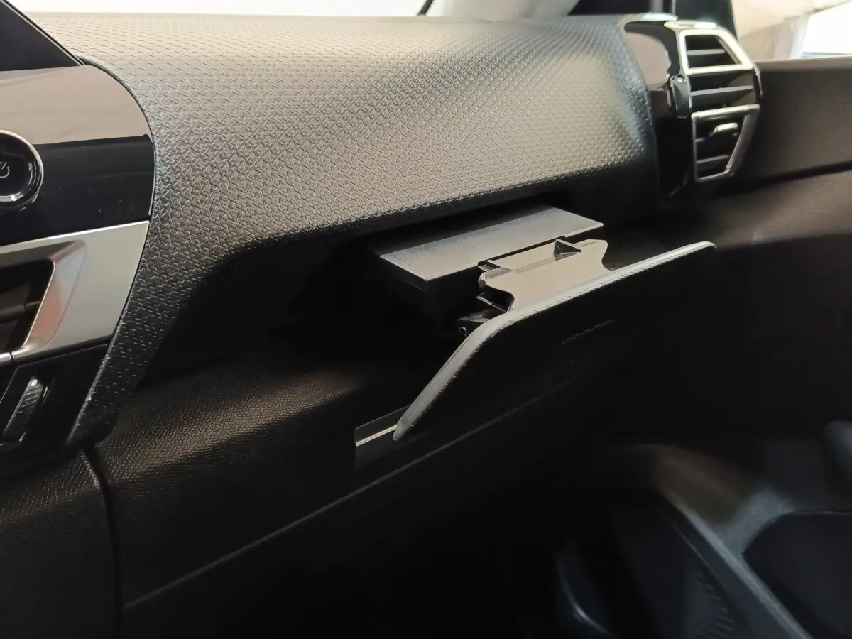Intérieur côté passager du Citroën C4 2022, détail de la boîte à gants ouverte avec tableau de bord texturé noir.
