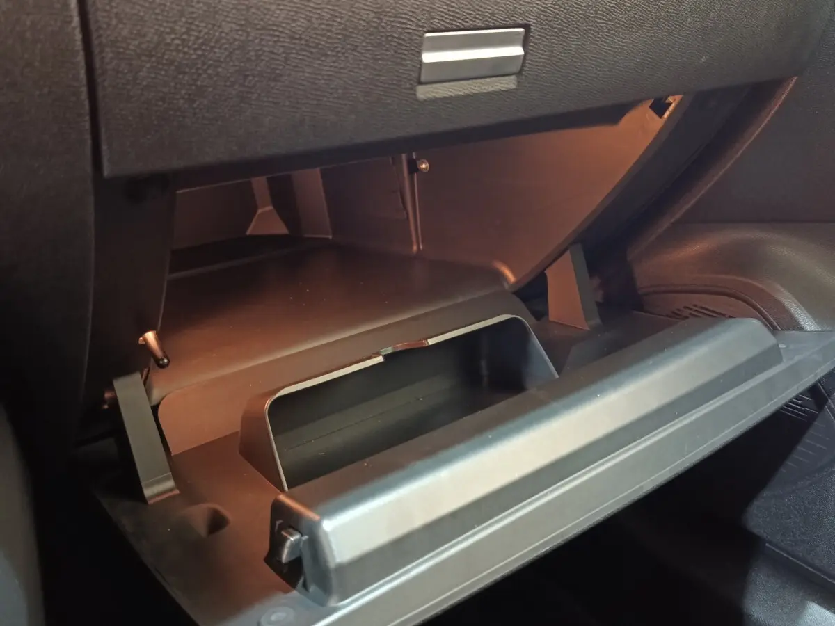 Vue rapprochée de la boîte à gants ouverte dans l’habitacle noir d’une Citroën C4 gris foncé 2022.